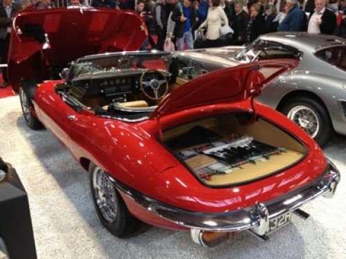 A concourse example of an E-Type Jaguar in Red at a Classic Car Show