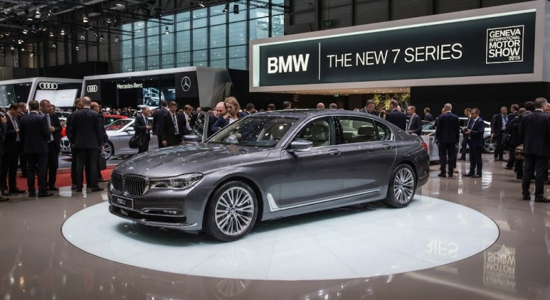 A 2015 BMW 7 Series on display at the Geneva International Motor Show, surrounded by attendees and event branding.